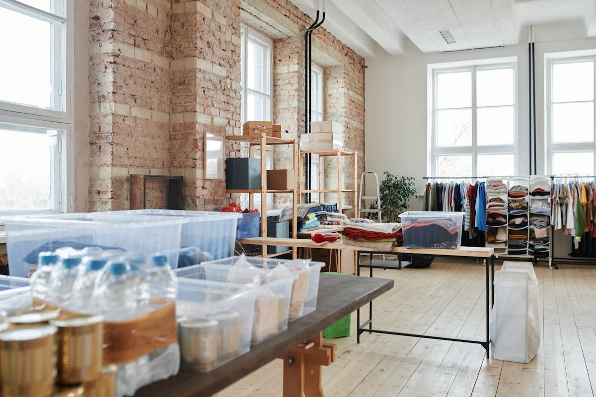 Organized clothing racks and packing boxes in a supply workspace.