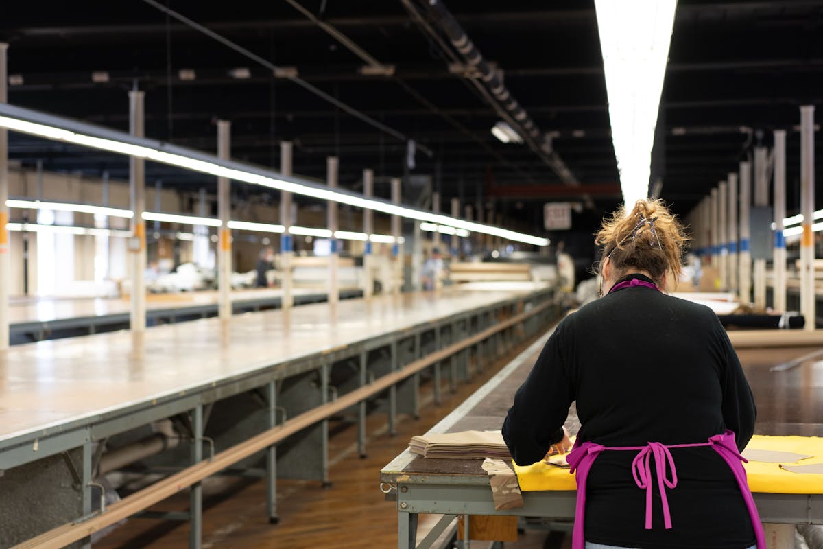 Garment production workspace with textile equipment and clothing manufacturing activity.